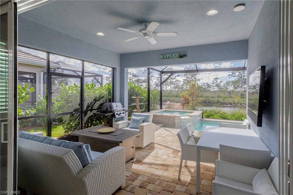 Sunroom / solarium featuring ceiling fan and a swimming pool