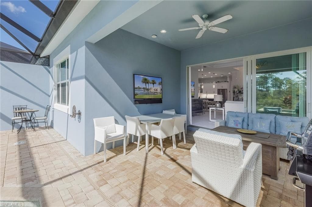 View of patio / terrace with outdoor lounge area, ceiling fan, and a lanai