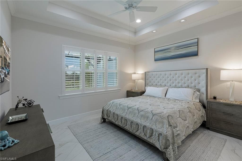 Bedroom with ceiling fan, a raised ceiling, and crown molding