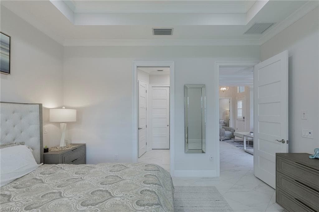 Bedroom featuring ensuite bathroom and ornamental molding