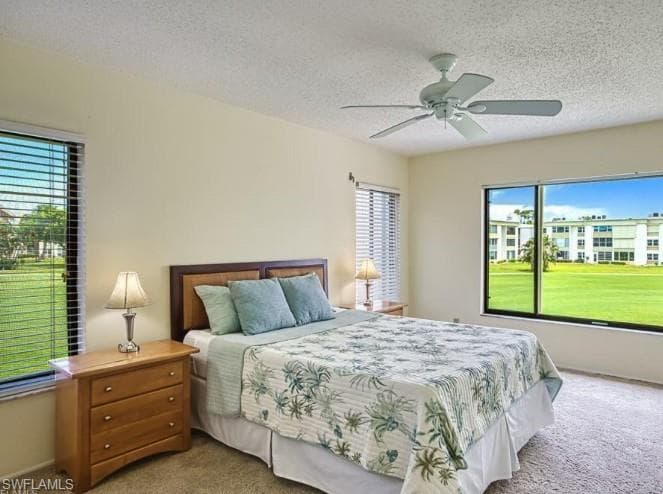 Carpeted bedroom with a textured ceiling and ceiling fan