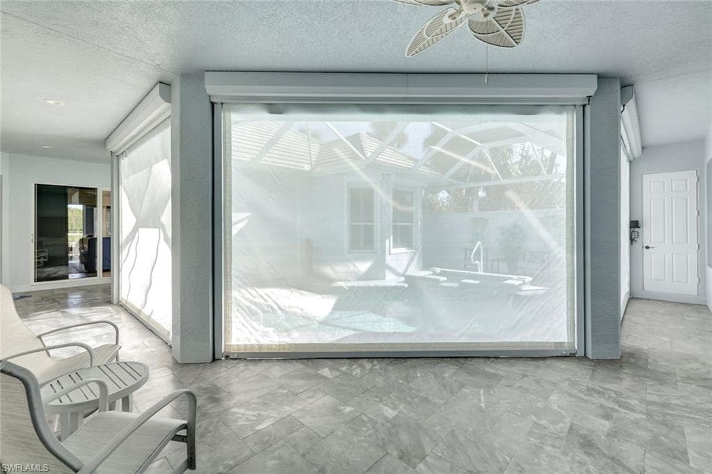 Pool and spa with electric hurricane fabric shutters in the down position