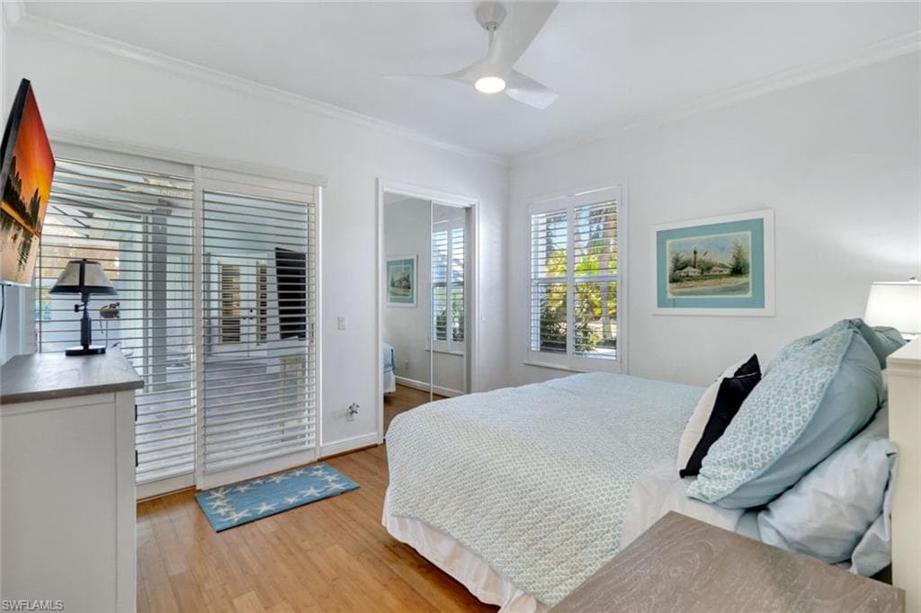 Bedroom featuring ceiling fan, light wood-type flooring, and crown molding right off of pool