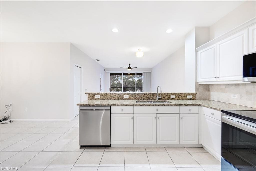 Kitchen with white cabinets, sink, ceiling fan, appliances with stainless steel finishes, and kitchen peninsula