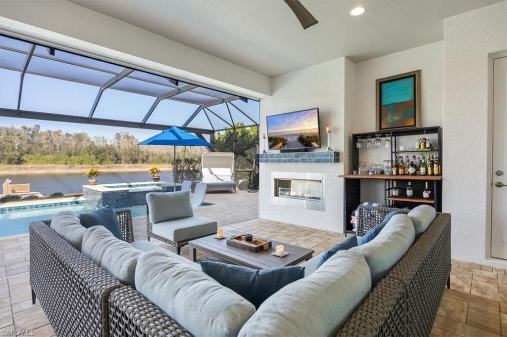 Outdoor living room comes complete with a gas fireplace, anti glare TV and bar area