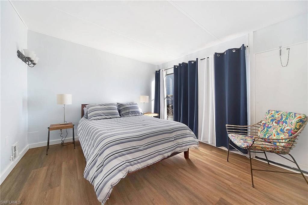 Bedroom with wood-style floors and fan.