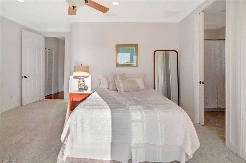 Carpeted bedroom featuring crown molding and ceiling fan