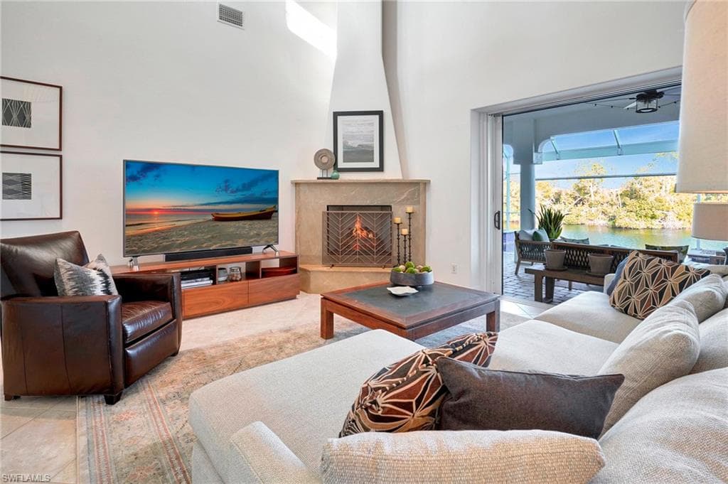 Living room with a towering ceiling and a high end fireplace