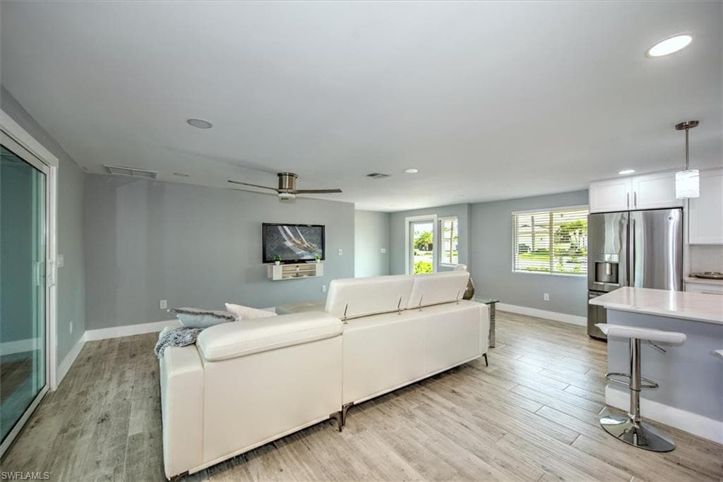 Living room featuring ceiling fan and light hardwood / wood-style floors