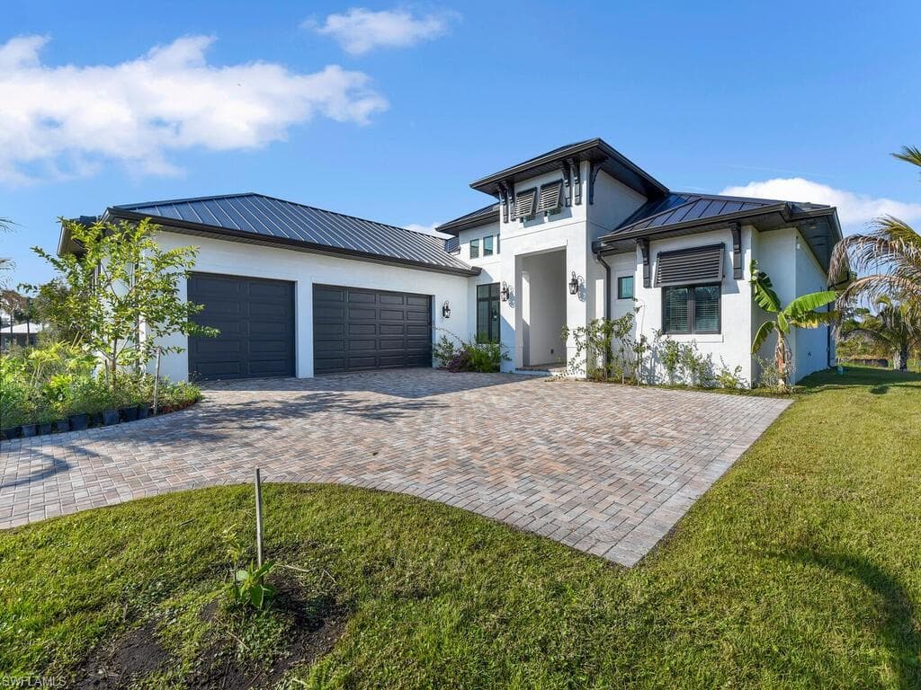 View of front of house with a garage and a front lawn