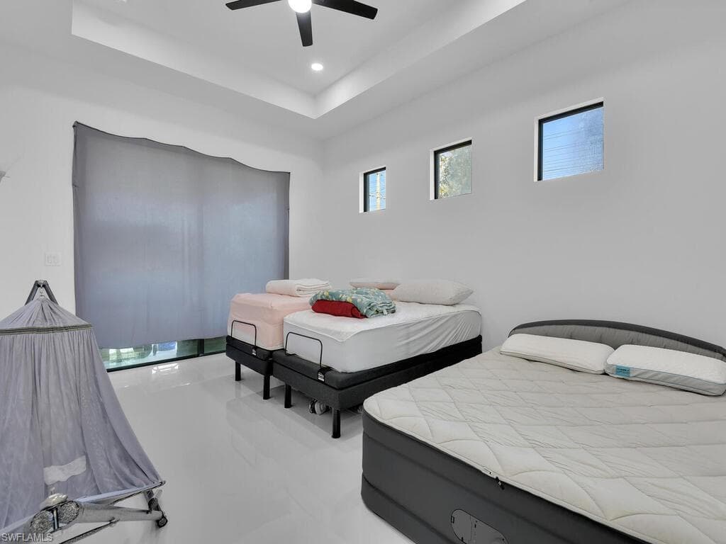 Bedroom with ceiling fan and a tray ceiling