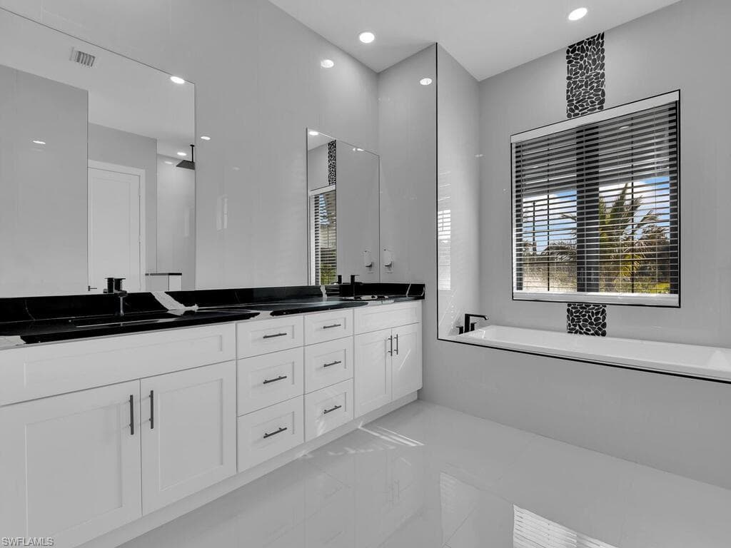 Bathroom featuring vanity, a bathing tub, and tile patterned flooring