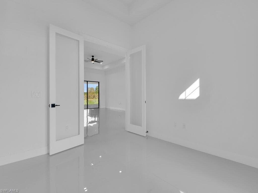 Empty room with ceiling fan and french doors