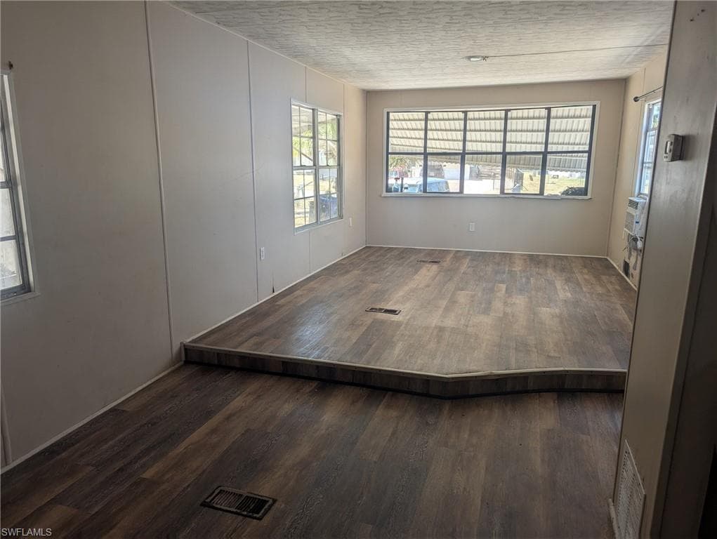 Unfurnished room featuring wood finished floors and visible vents
