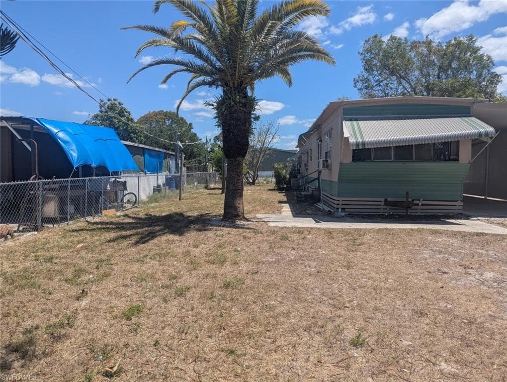 View of yard with entry steps and fence
