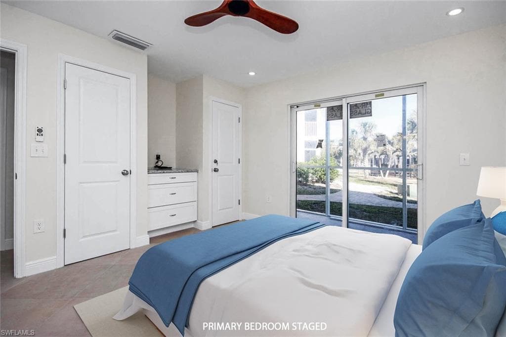 Tiled bedroom with ceiling fan and access to outside