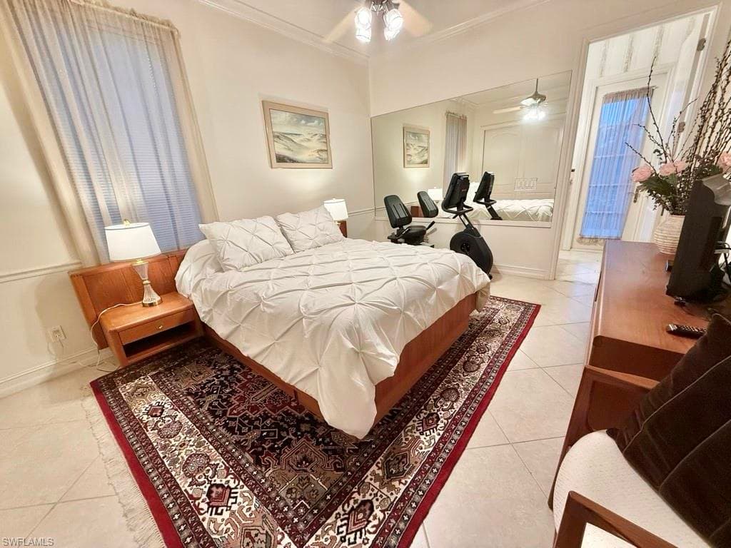 Tiled bedroom with ornamental molding and ceiling fan