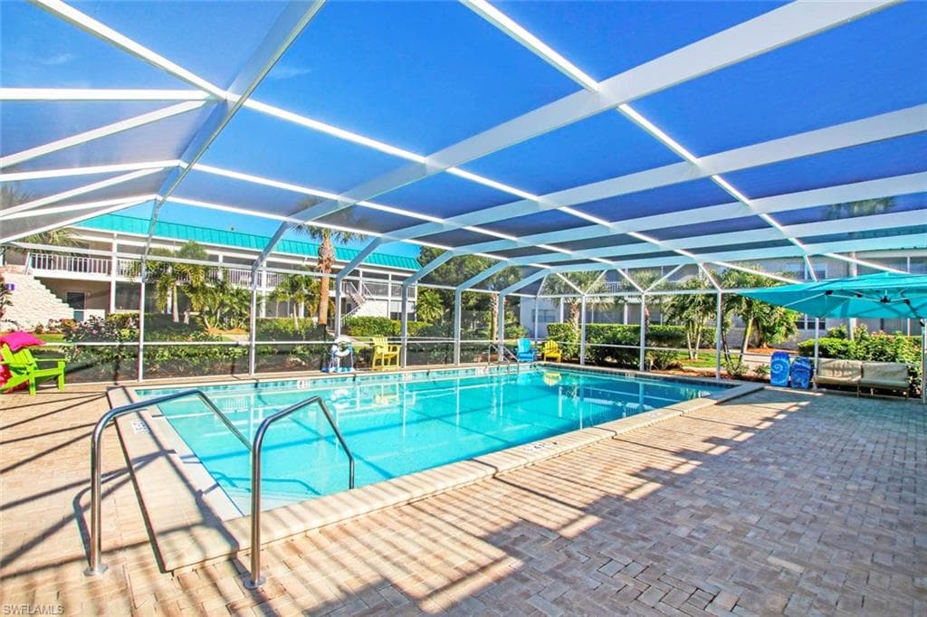 View of swimming pool featuring a lanai and a patio area