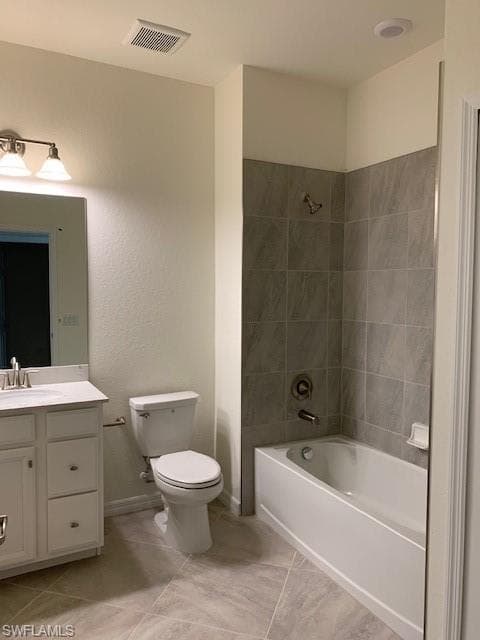 Full bathroom with vanity, tile patterned floors, toilet, and tiled shower / bath