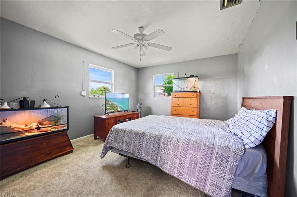 Carpeted bedroom featuring ceiling fan