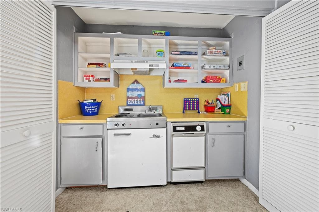 Kitchen featuring light carpet and white range oven