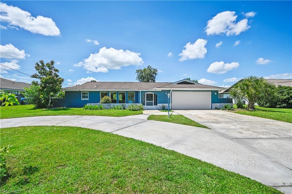 Single story home with a garage and a front yard