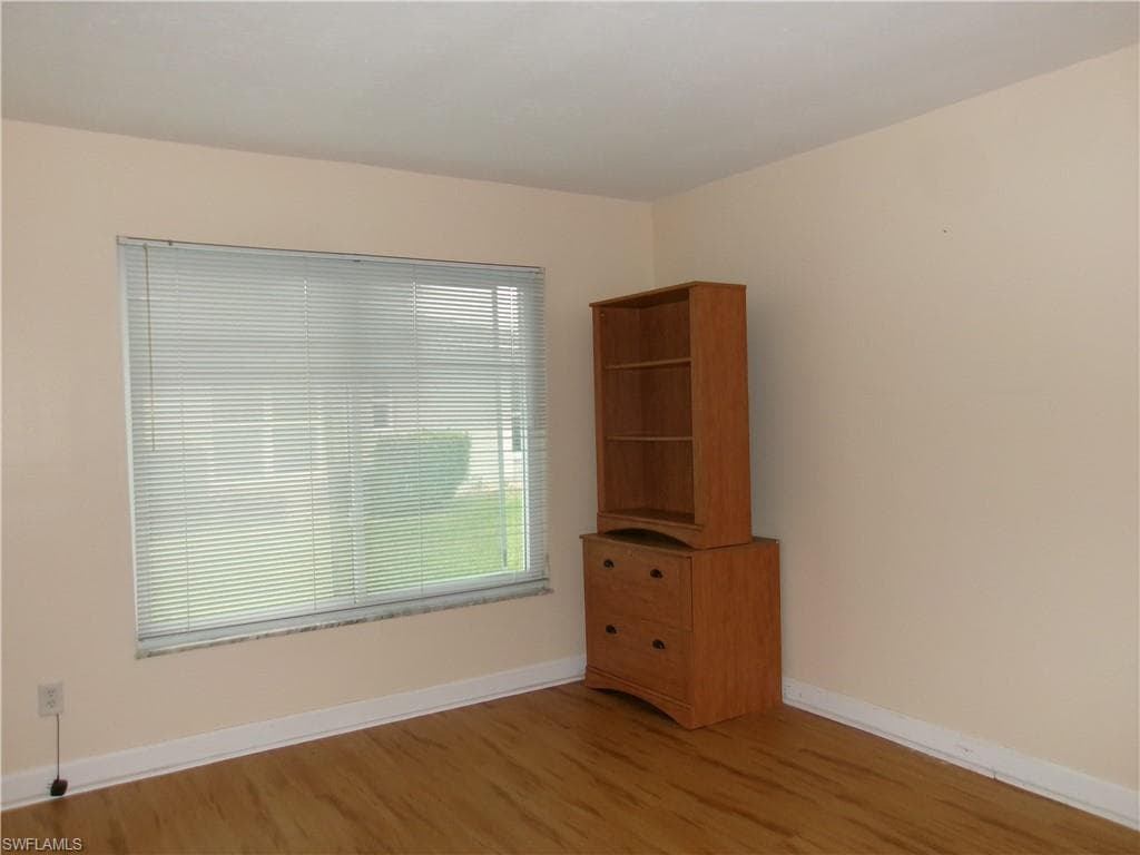 Spare room featuring wood finished floors and baseboards