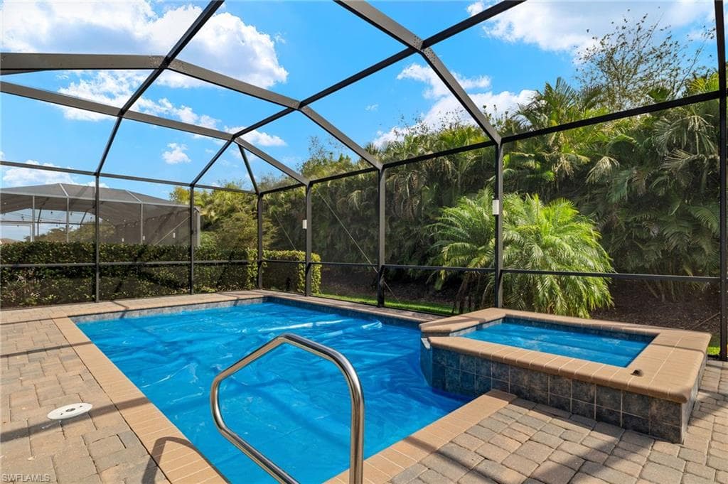 View of pool featuring an in ground hot tub and a lanai