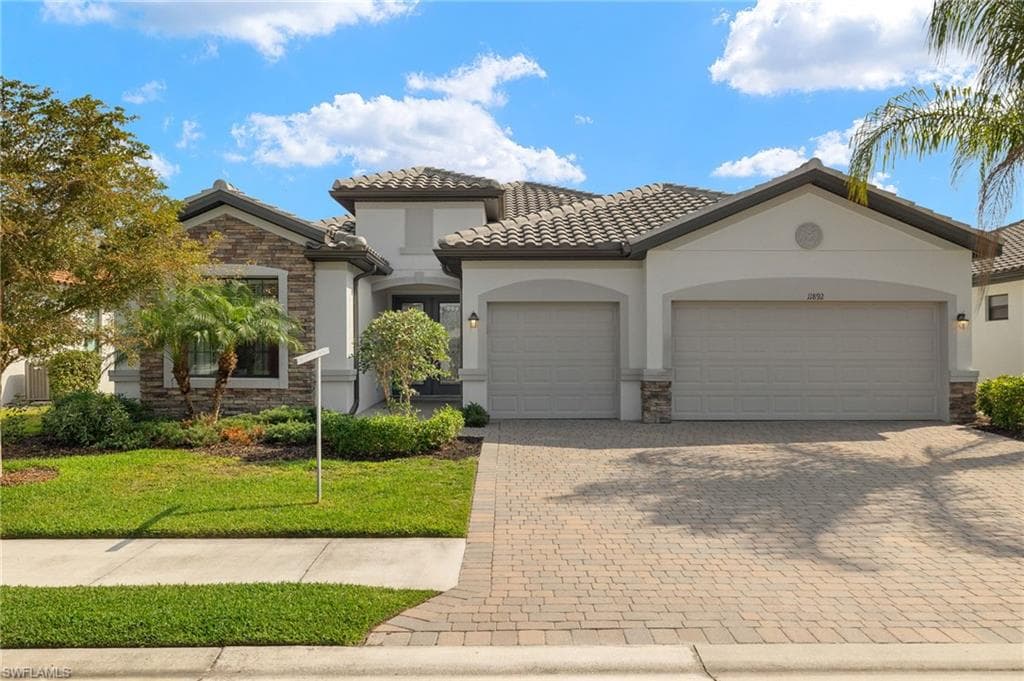 Mediterranean / spanish house featuring a garage and a front yard