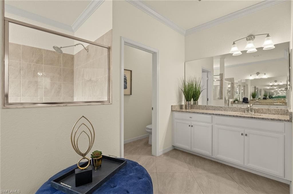Bathroom with ornamental molding, vanity, toilet, and walk in shower