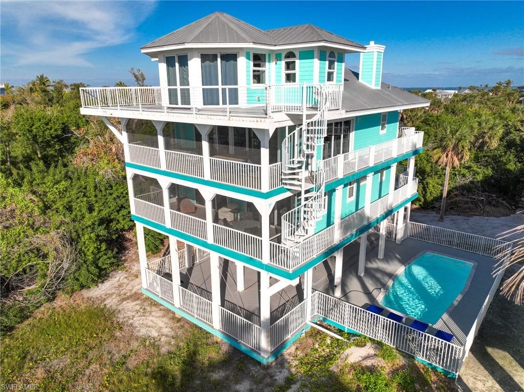 Back of property with metal roof and a community pool