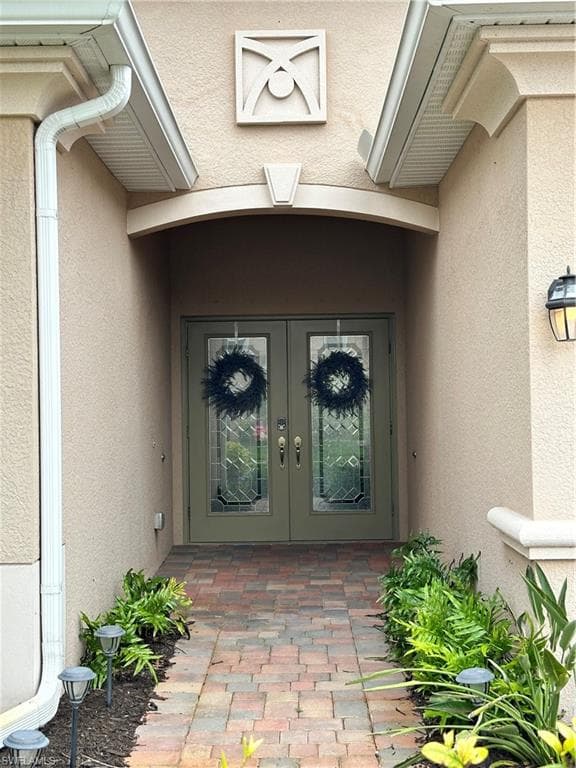 Entrance to property with stucco siding and french doors