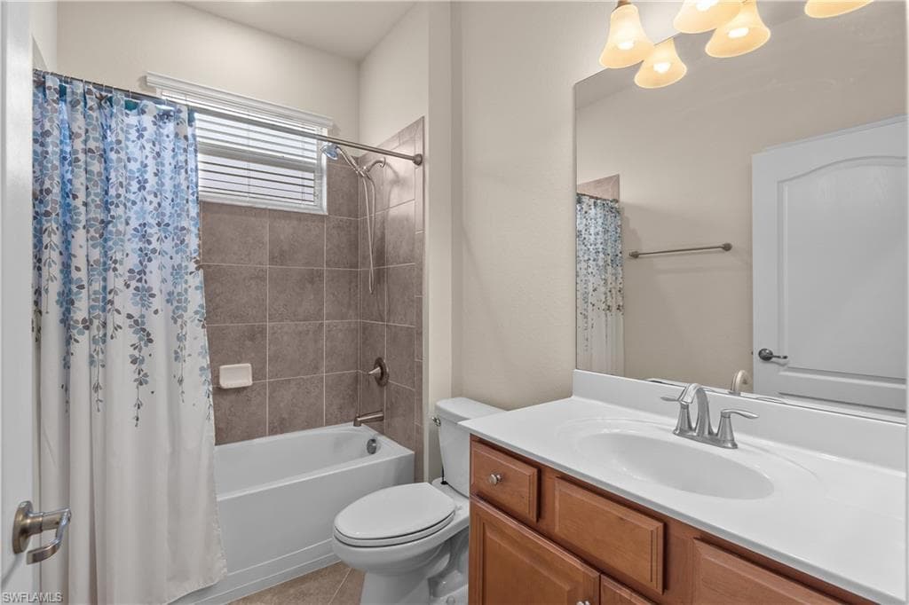 Full third bathroom featuring toilet, shower / bath combo, vanity, and tile patterned floors