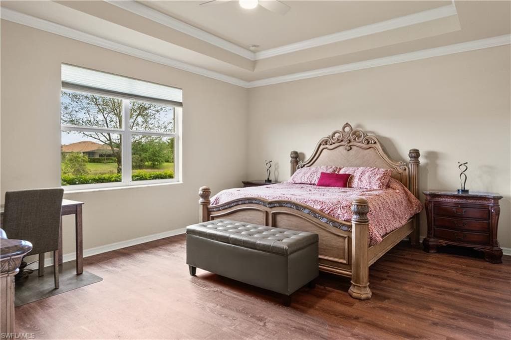 Spacious Master Bedroom featuring crown molding, a raised ceiling, luxury vinyl floors