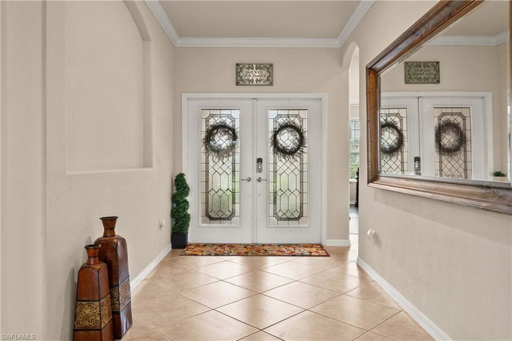 Entrance foyer featuring a wealth of natural light, french doors, and crown molding