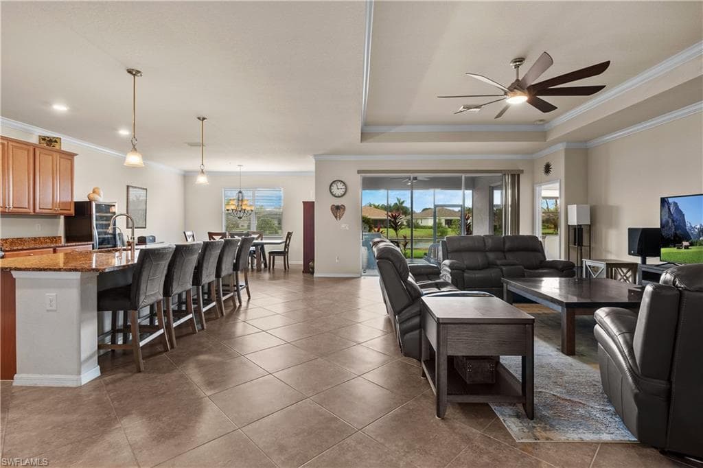 Great Room featuring a tray ceiling, ornamental molding, and tile patterned floors