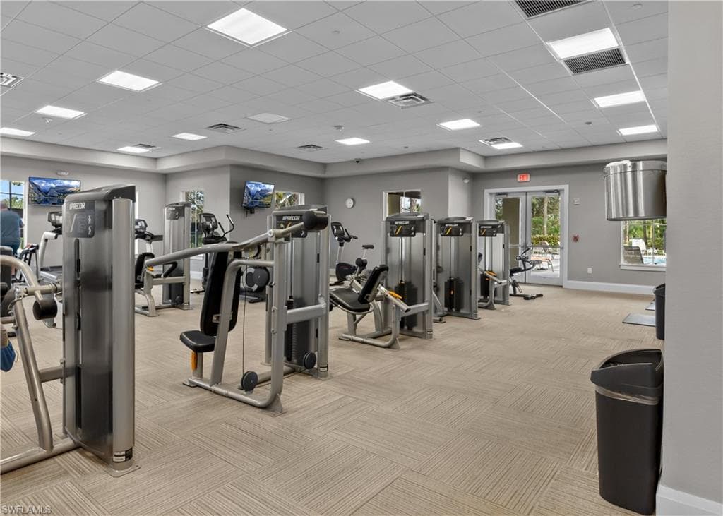 Community Exercise room featuring light carpet, visible vents, and baseboards