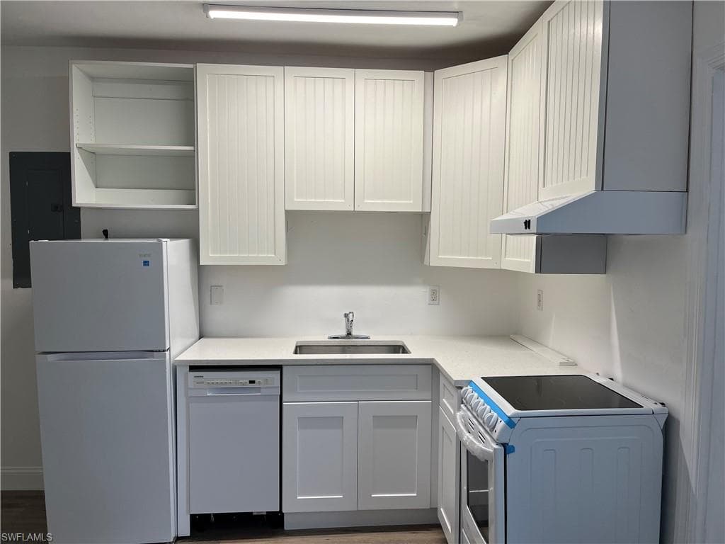 Kitchen featuring white appliances, washer / dryer, electric panel, open shelves, and light countertops