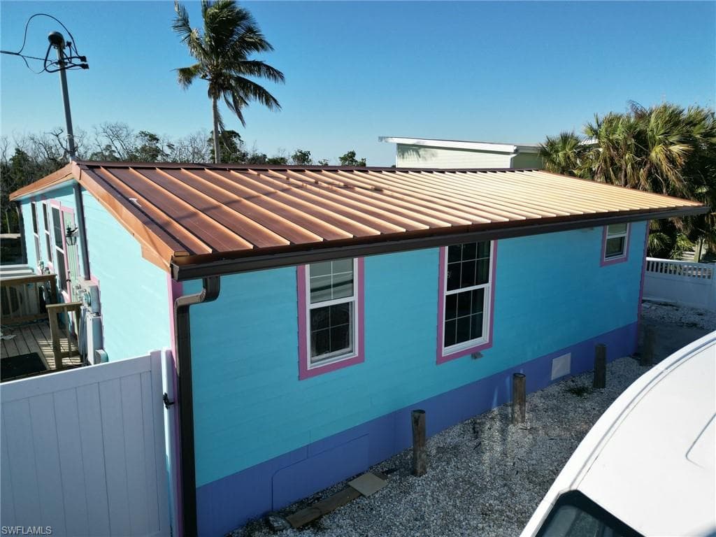 View of property exterior with a Metal roof and fence