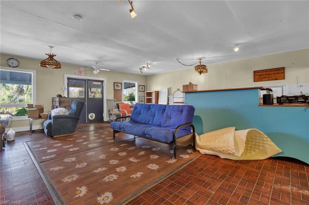 Living room featuring brick floor and baseboards
