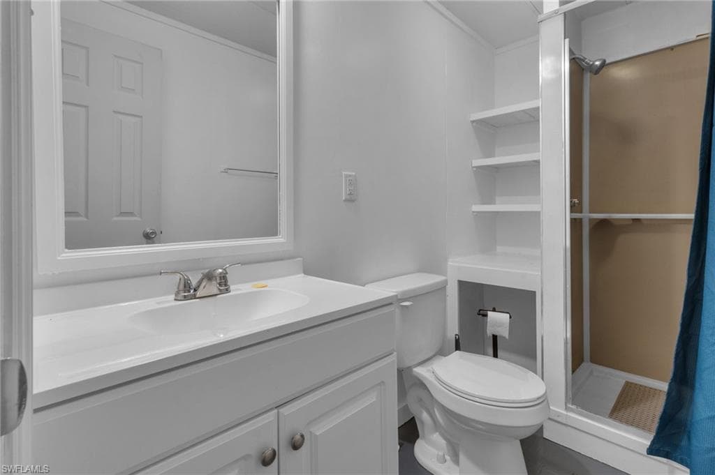 Full bathroom with toilet, a stall shower, and vanity