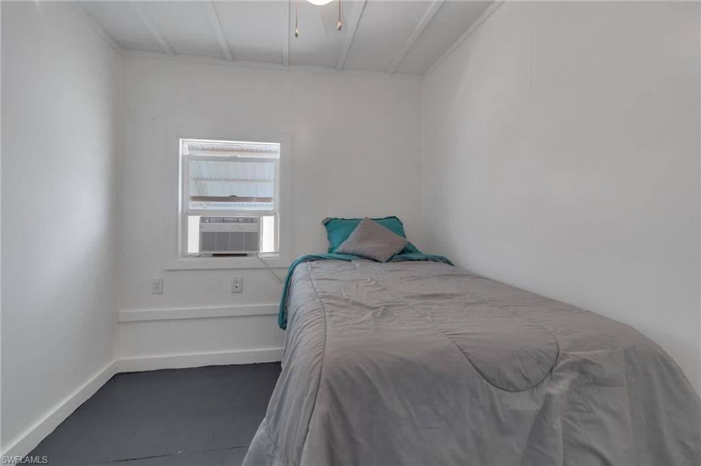 Bedroom featuring cooling unit and baseboards