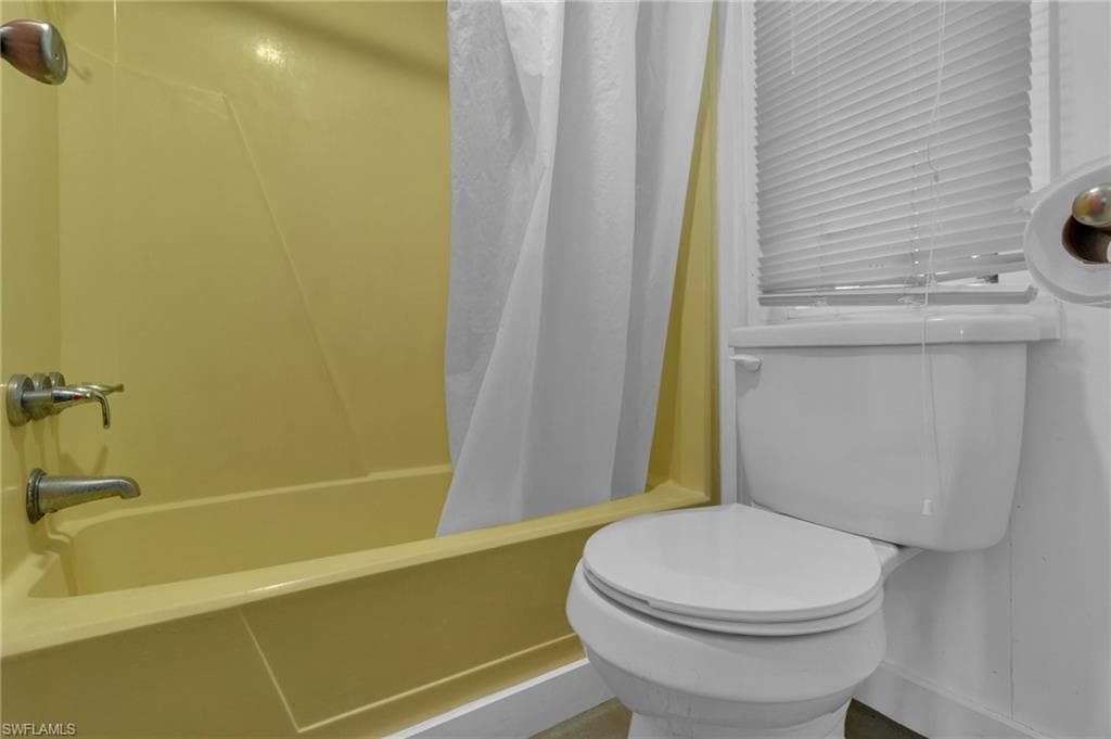 Full bath featuring shower / bath combo and toilet