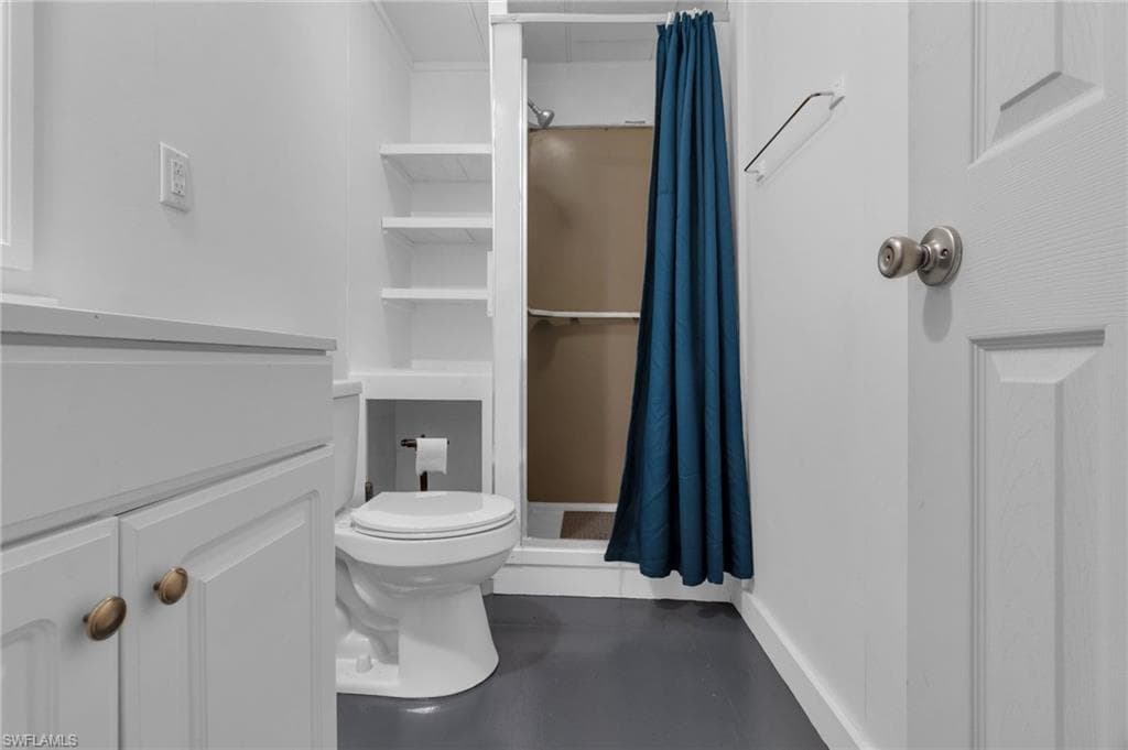 Bathroom with toilet and a shower with shower curtain