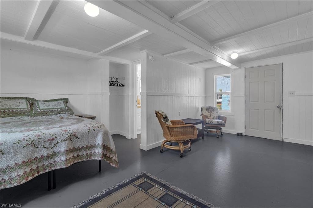 Bedroom featuring wood floors and beam ceiling