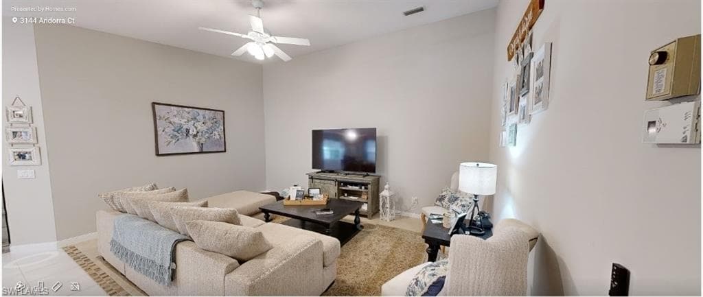 Living area featuring ceiling fan and baseboards