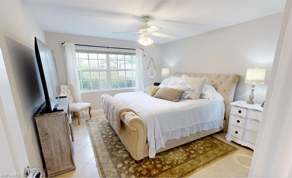 Bedroom with light tile patterned floors and ceiling fan