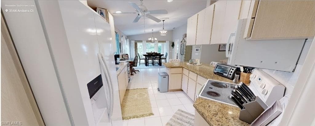 Kitchen featuring white appliances, lofted ceiling, light tile patterned floors, light stone countertops, and pendant lighting