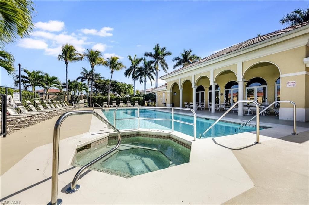 Pool with a patio area and a hot tub