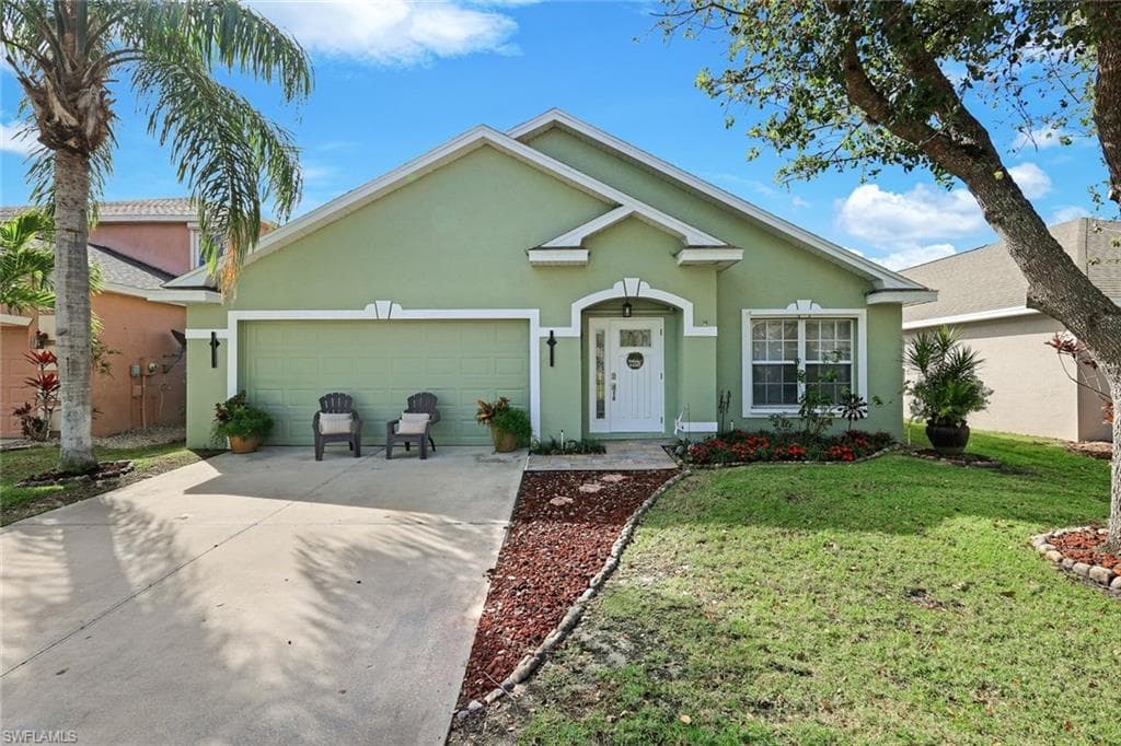 Single story home featuring an attached garage, a front yard, concrete driveway, and stucco siding